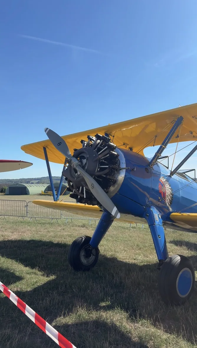 Biplan à moteur en étoile exposé sur l'herbe lors du Fly-in de Persan-Beaumont